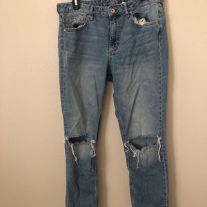 Blue denim jeans with knee cutouts